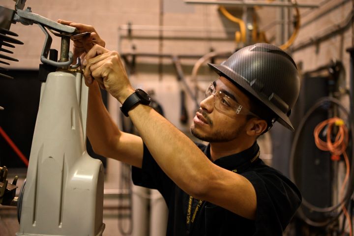 An S&C team member mounts a TripSaver II Cutout Mounted Recloser for testing An S&C team member mounts a TripSaver II Cutout Mounted Recloser for testing