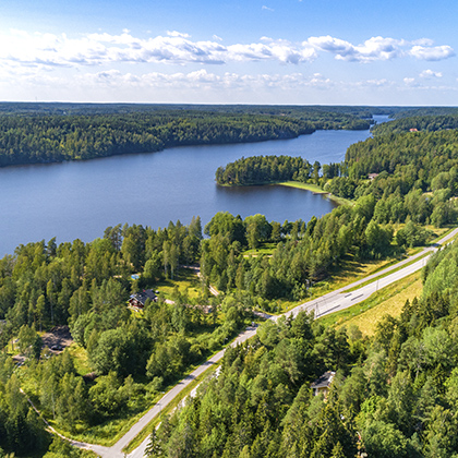 An aerial photo of a highway running through a forest highway, forest, nature, environment, green, trees, water