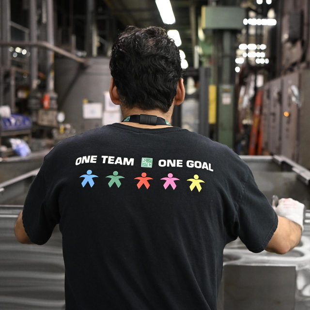 A team member displays S&C's "one team, one goal" slogan A team member displays S&C's "one team, one goal" slogan
