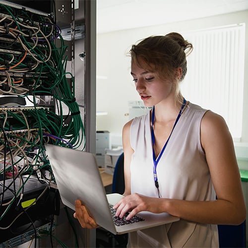 A young female technician is checking the server