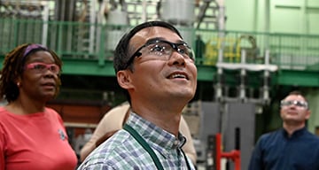 Workers wearing protective glasses looking up and smiling Workers wearing protective glasses looking up and smiling